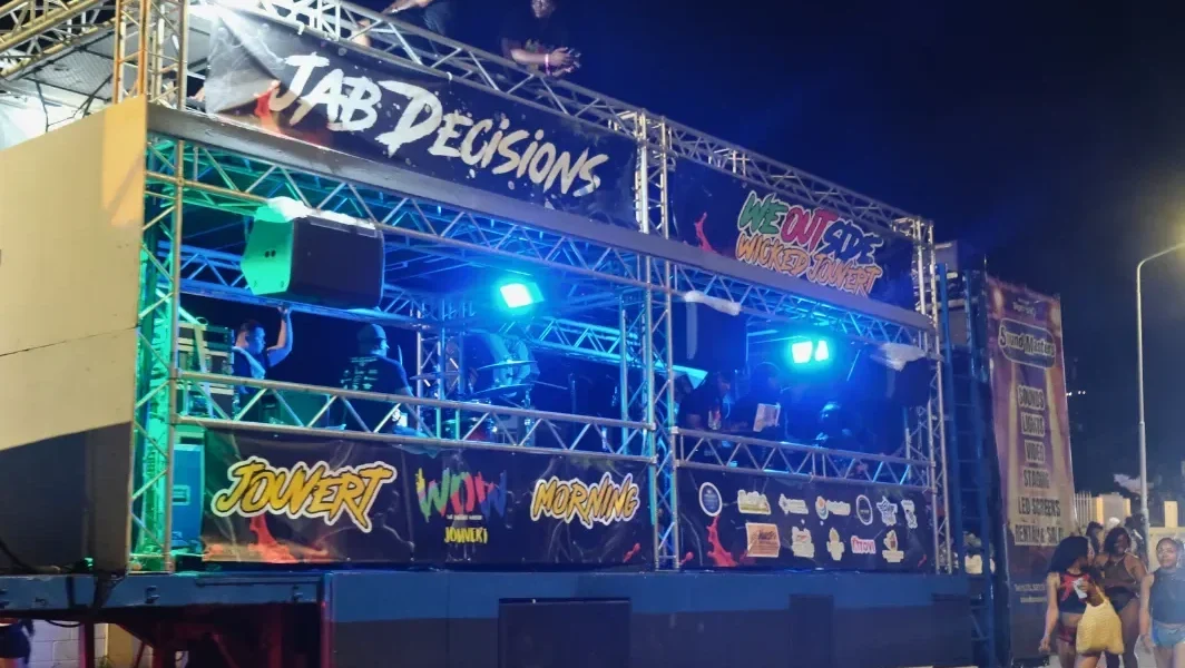 J'ouvert music truck lit up in blue and green in the dark before dawn at Caribbean Carnival