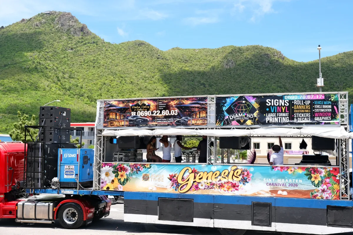 A mas band music truck branded for Sint Maarten Carnival 2026 parked on the route with speaker stacks and a DJ booth