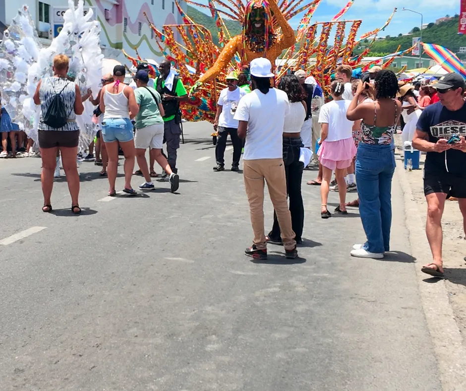Spectators watching colorful costumed performers during the SXM Carnival parade in Philipsburg