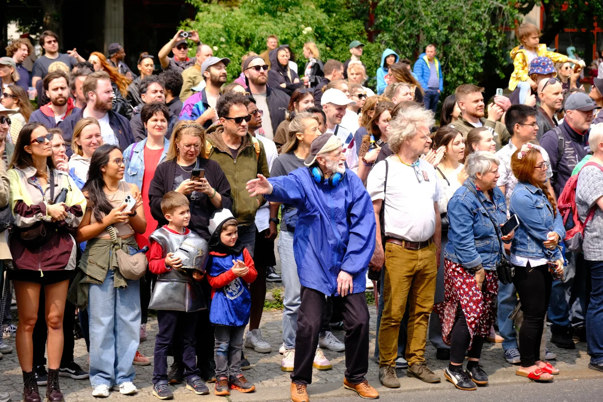 Spectators stand shoulder to shoulder along the Berlin Carnival parade route watching performers and taking photos