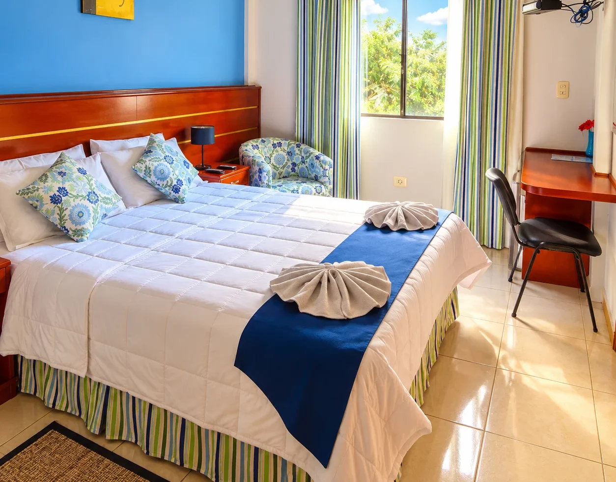 Twin and double beds in a carpeted guest room at Le Club Resort Hotel with a purple feature wall