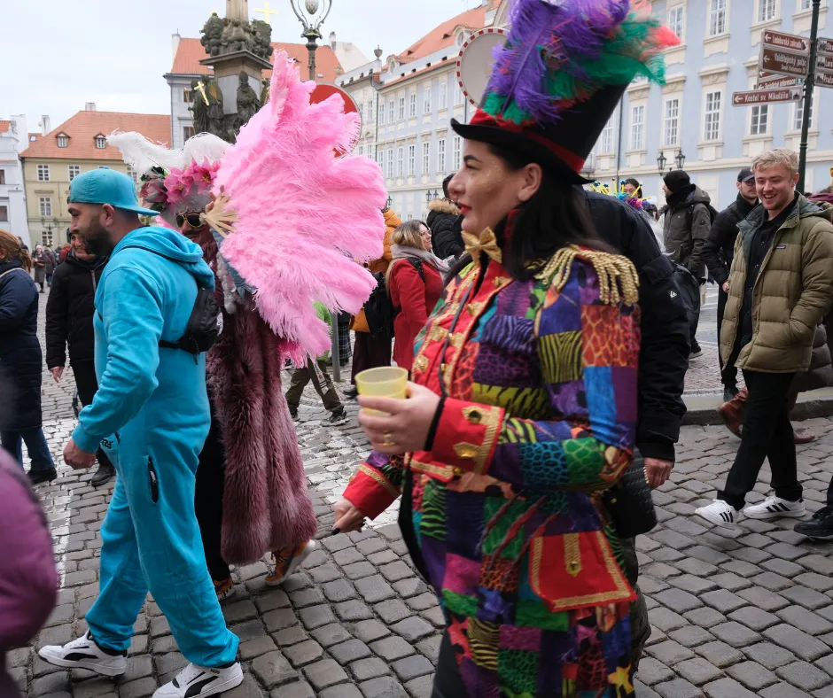 Masopust revelers in colourful costumes celebrating in Prague with traditional honey wine and festive drinks